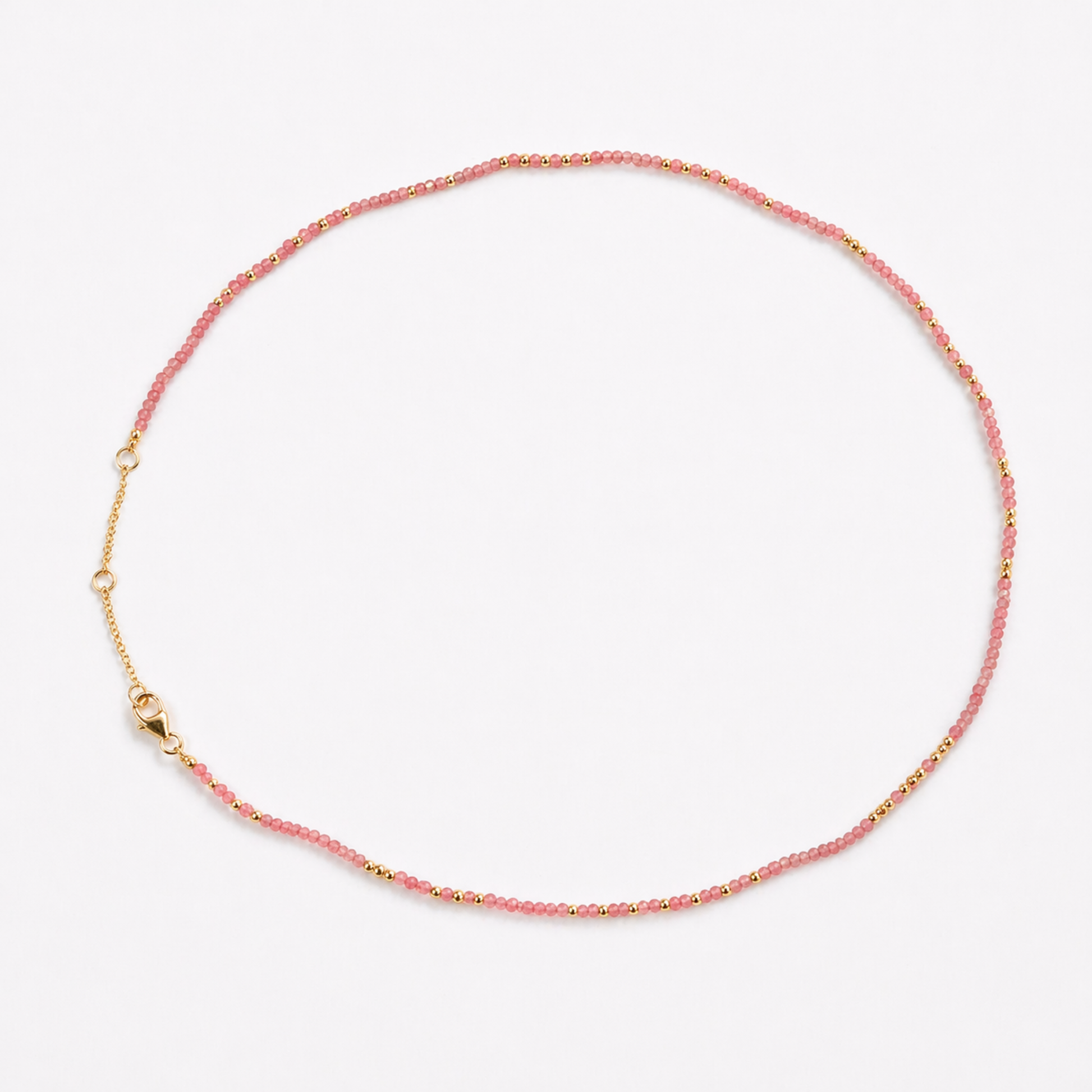 A full studio shot of the Everyday Glow necklace on a white background, displaying the delicate beaded strand and the adjustable 18kt gold plated lobster clasp.