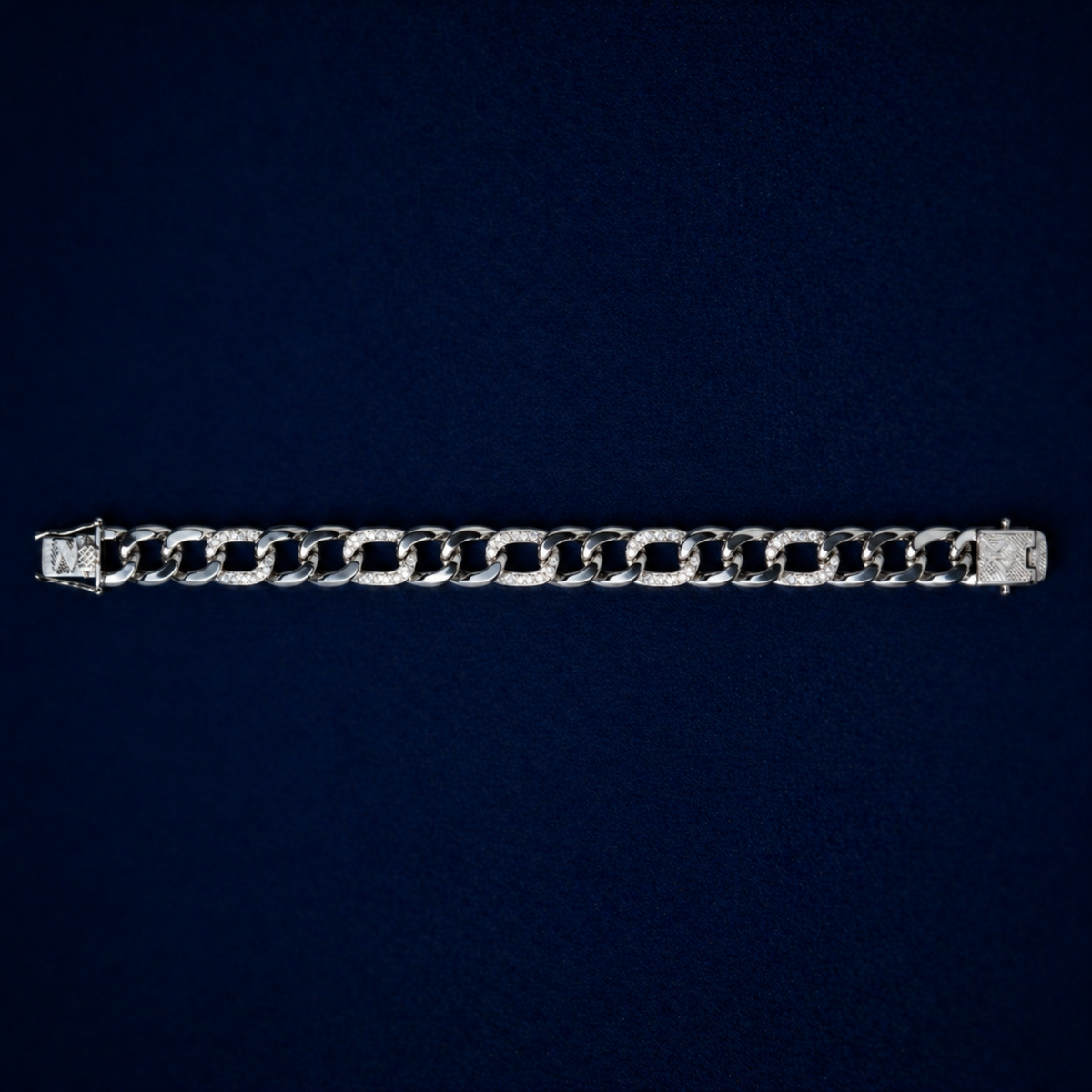 A full-length top-down view of the Effortless Edge bracelet on a dark navy background, displaying the rhythmic pattern of polished and stone-encrusted silver links.
