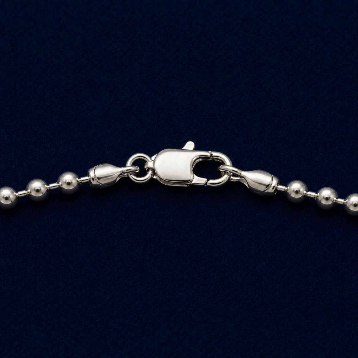 A detailed close-up of the Everyday Soft Glow necklace highlighting the substantial weight, the polished silver bead texture, and the secure lobster clasp closure.
