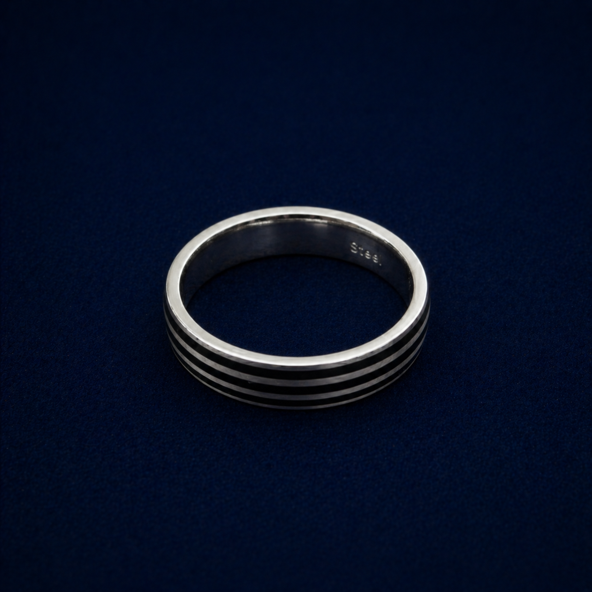 An angled shot of the handcrafted Midnight Trio Ring, highlighting the three sleek black enamel parallel lines inlaid into a polished 925 sterling silver band.