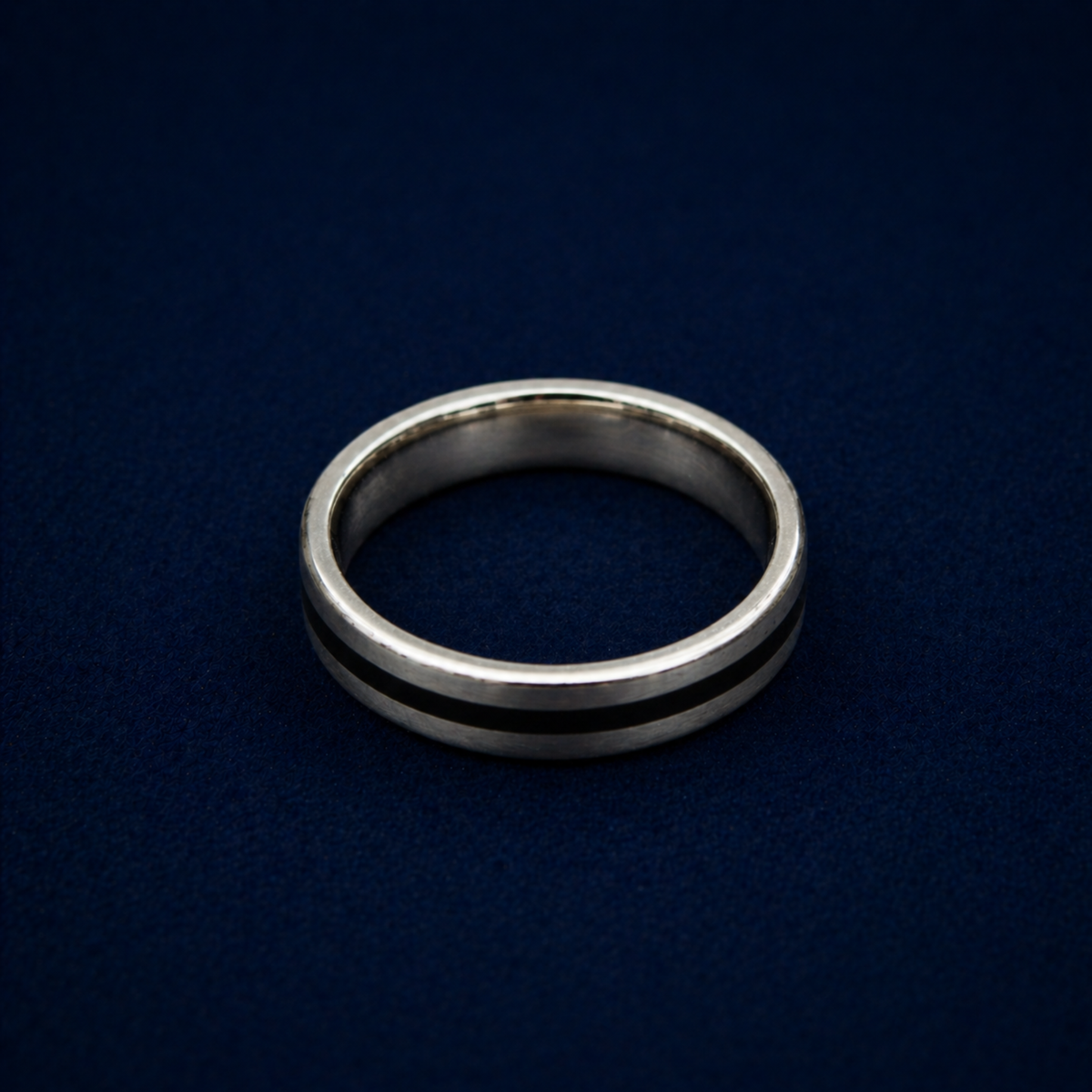 An angled shot of the Midnight Edge Ring highlighting the sleek black enamel stripe inlay on a polished sterling silver band for a modern, contemporary look.