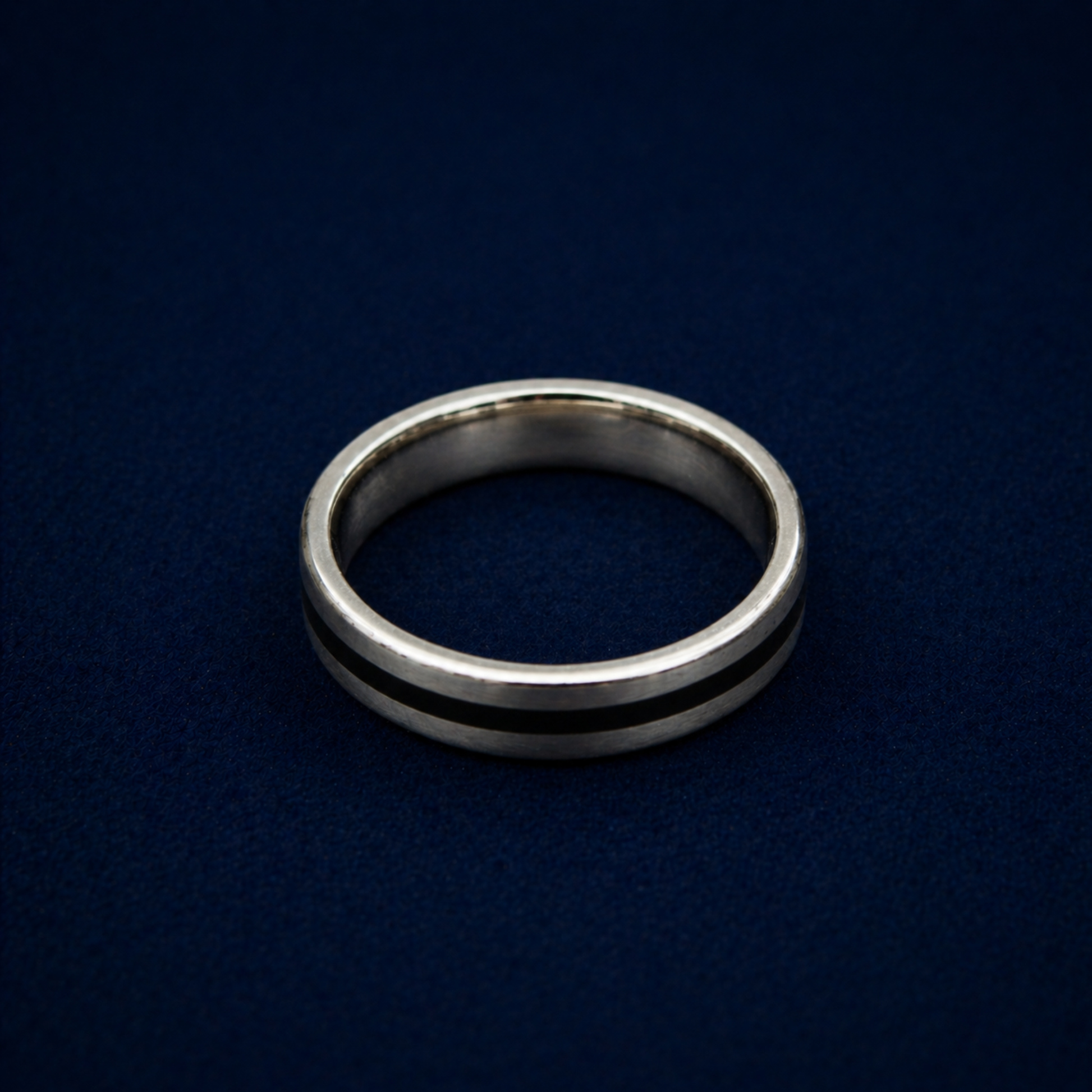 An angled shot of the Midnight Edge Ring highlighting the sleek black enamel stripe inlay on a polished sterling silver band for a modern, contemporary look.