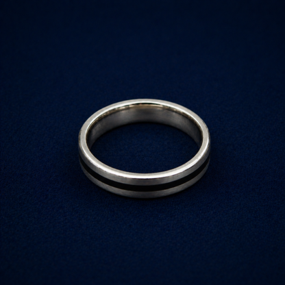 An angled shot of the Midnight Edge Ring highlighting the sleek black enamel stripe inlay on a polished sterling silver band for a modern, contemporary look.