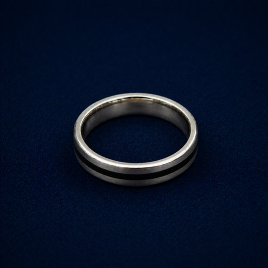 An angled shot of the Midnight Edge Ring highlighting the sleek black enamel stripe inlay on a polished sterling silver band for a modern, contemporary look.