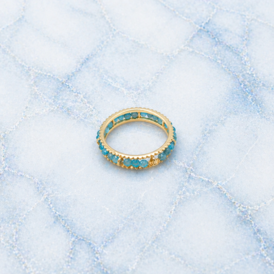 An angled shot of the handcrafted Midnight Ball Ring, highlighting the smooth ball-shaped blue-black jade stones and the polished golden eternity-style setting.