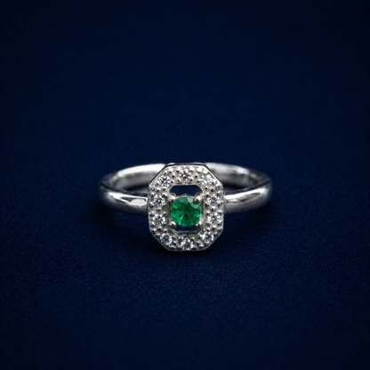 Frontal view of the Evergreen Spark Ring on a dark navy background, displaying the geometric octagonal halo design and the polished silver finish.