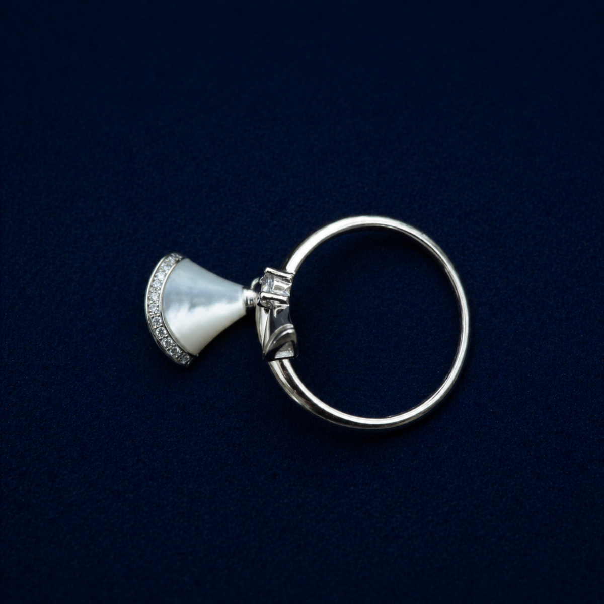Top-down view of the Twilight Curve Ring showcasing the modern open-wrap silhouette with a central sparkling CZ stone and a pavé-set shimmering fan charm.