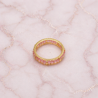 An angled shot of the handcrafted Blush Ball Ring, highlighting the delicate pink tourmaline stones and the polished golden eternity-style setting for a modern, layered look.