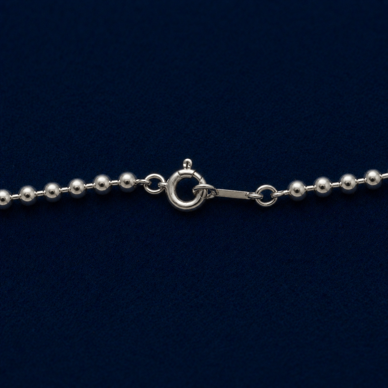 A detailed close-up of the Subtle Minimal Shine necklace highlighting the polished finish of the small silver beads and the secure spring ring closure.