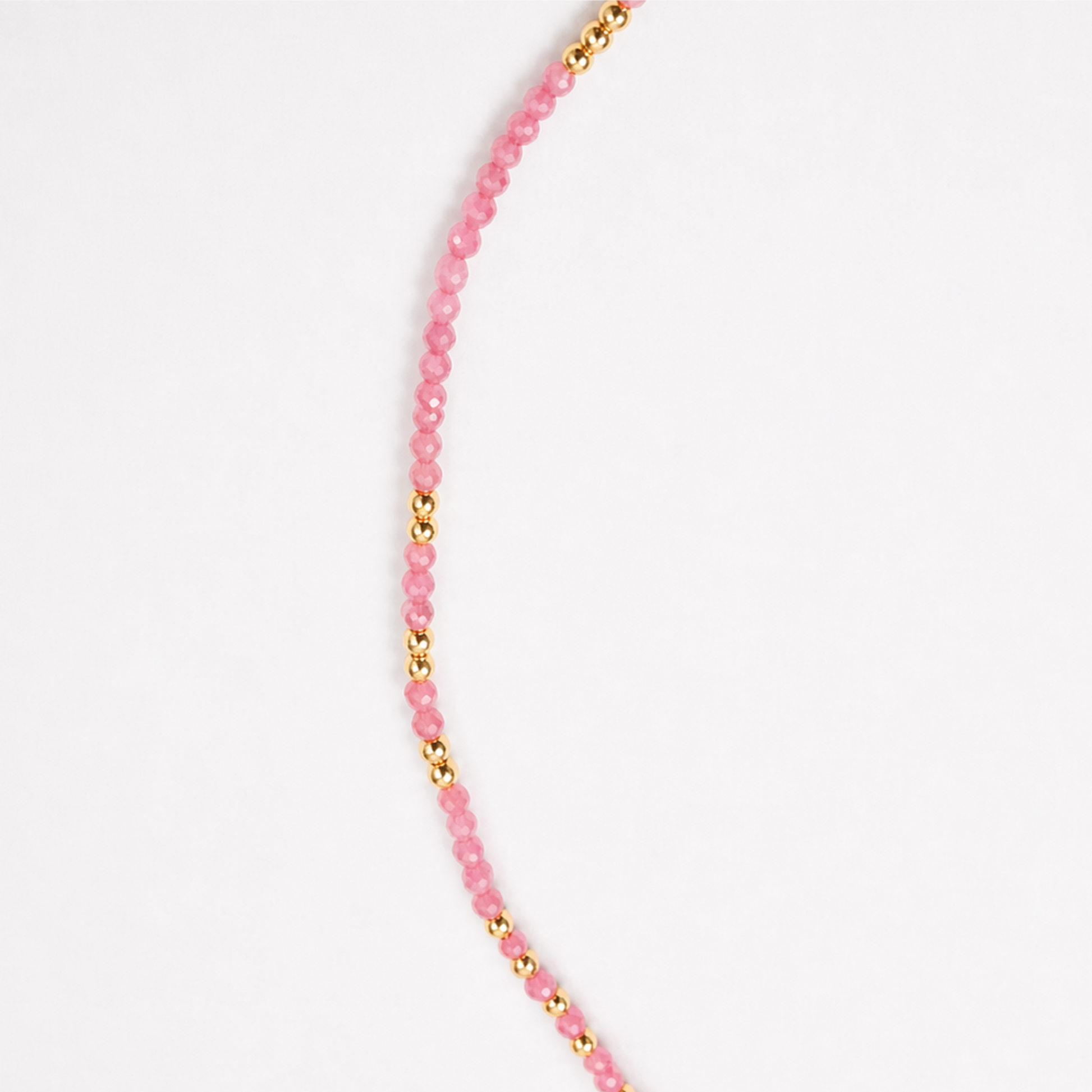 A detailed close-up of the Everyday Glow necklace showing the rhythmic pattern of faceted pink multi-stone beads and polished gold-plated sterling silver accents.