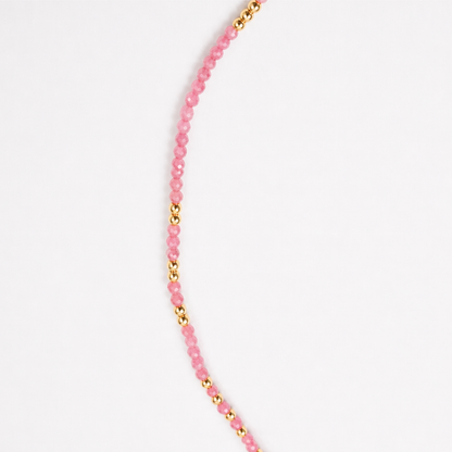 A detailed close-up of the Everyday Glow necklace showing the rhythmic pattern of faceted pink multi-stone beads and polished gold-plated sterling silver accents.