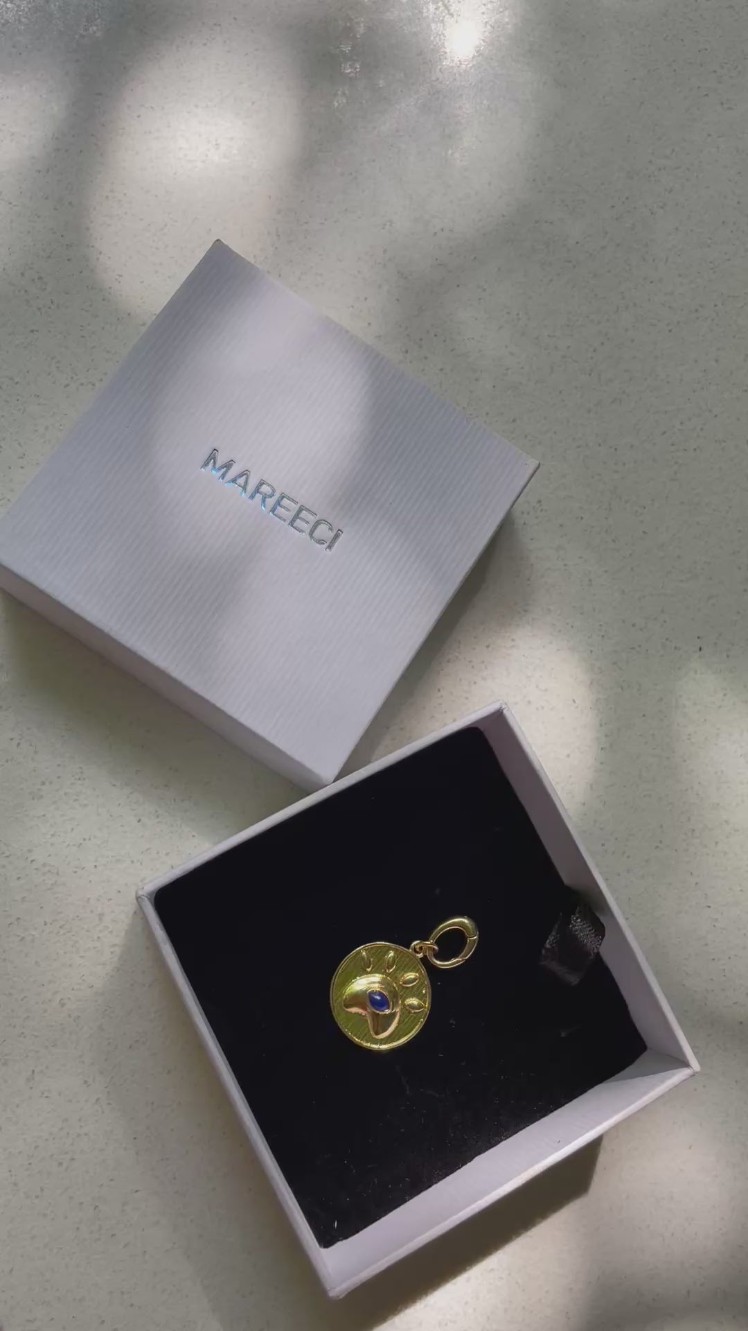 Eye of Love gold-tone charm with lapis lazuli in paw-inspired heart frame