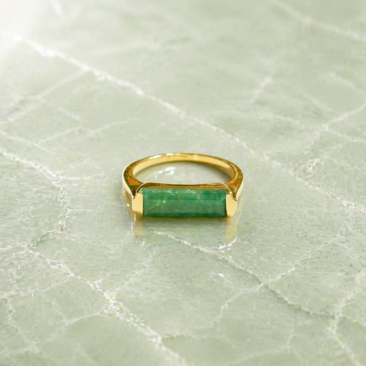 Frontal view of the Calm Elegance Ring highlighting the soothing green hue of the rectangle-cut aventurine stone and the structured, polished 18kt gold plated setting.
