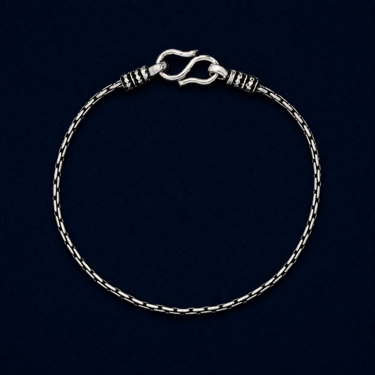 A full studio shot of the handcrafted Rhythm Bar anklet in 925 sterling silver, showcasing the modern brick-style structured links and secure S-hook clasp on a dark navy background.