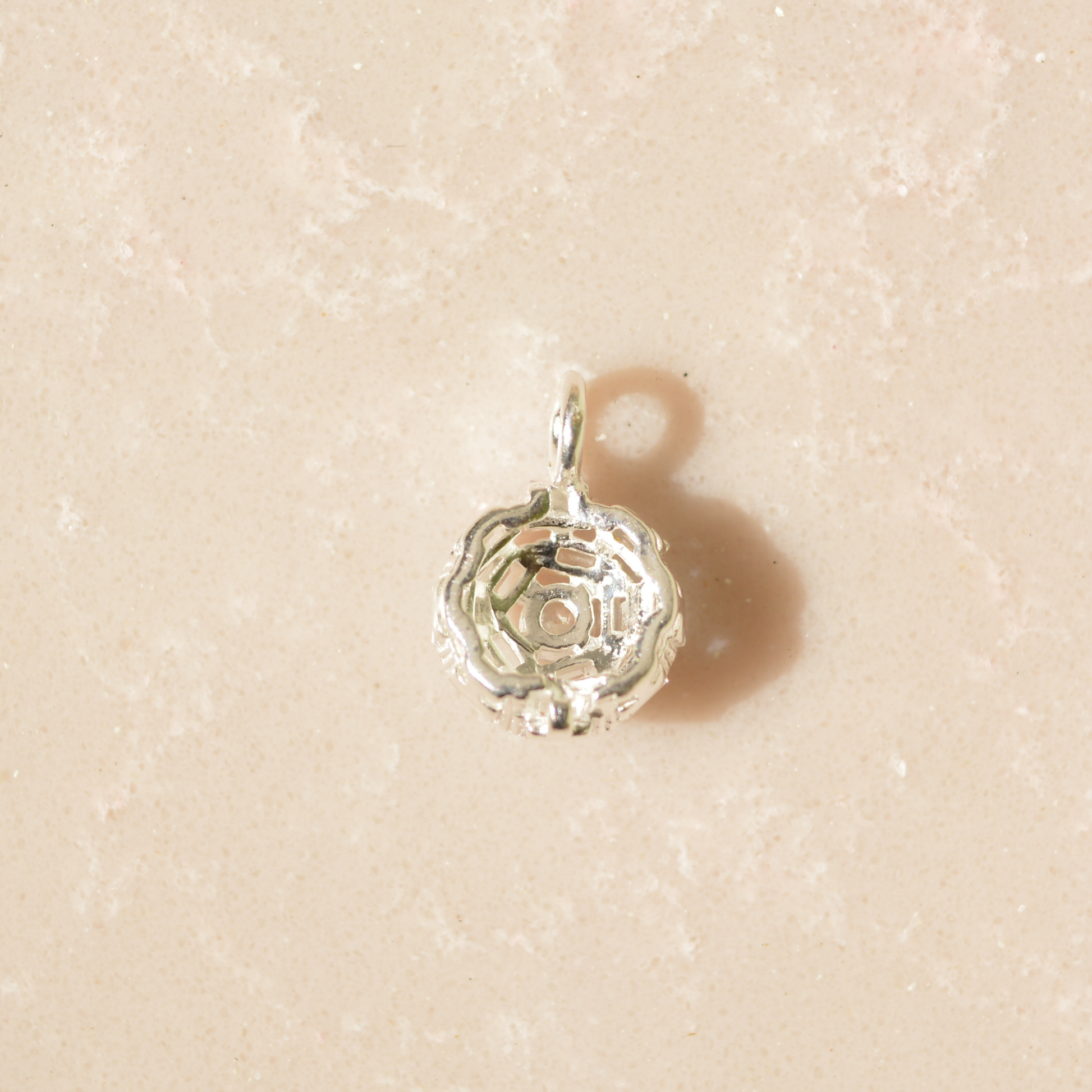 Rear view of the handcrafted 925 sterling silver Soft Sparkle pendant, showing the intricate geometric open-work setting on a neutral textured background.