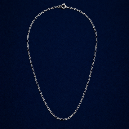 A full studio shot of the handcrafted Subtle Minimal Edge necklace in 925 sterling silver, featuring a modern elongated paperclip link design on a dark navy background.