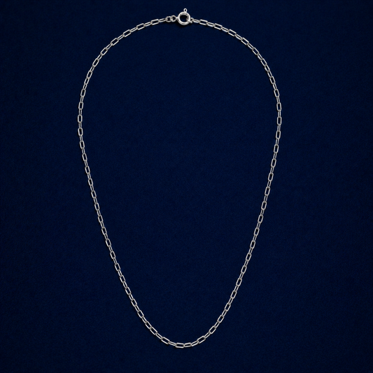 A full studio shot of the handcrafted Subtle Minimal Edge necklace in 925 sterling silver, featuring a modern elongated paperclip link design on a dark navy background.