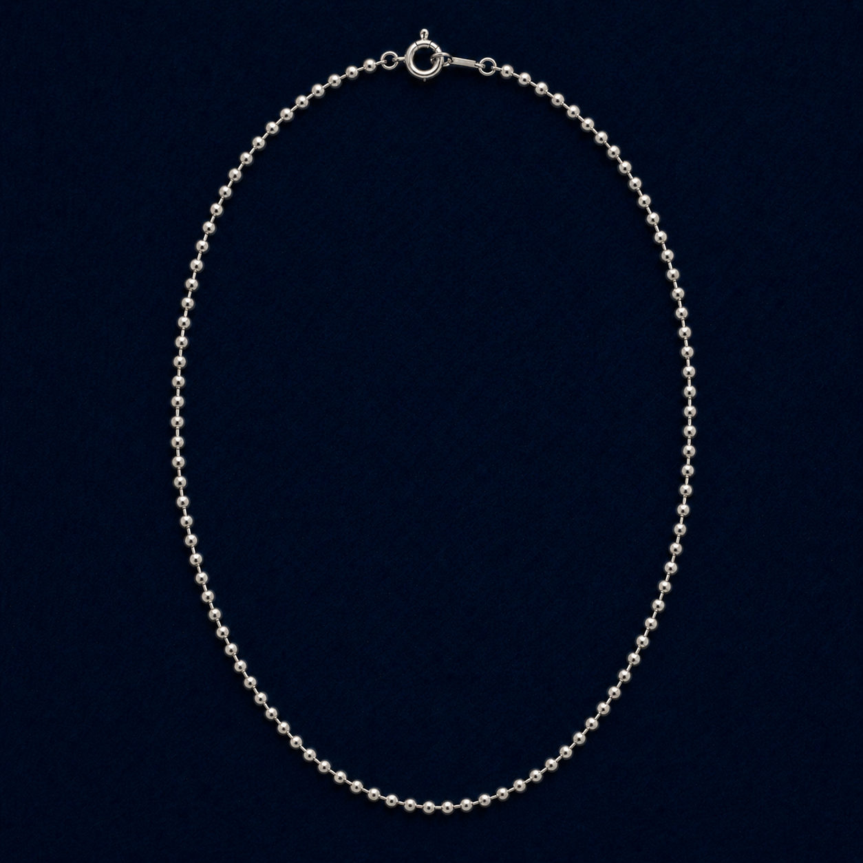 A full studio shot of the handcrafted Subtle Minimal Shine necklace in 925 sterling silver, featuring a delicate silver bead chain design on a dark navy background.