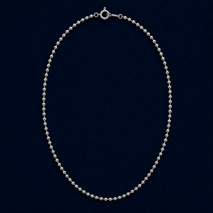 A full studio shot of the handcrafted Subtle Minimal Shine necklace in 925 sterling silver, featuring a delicate silver bead chain design on a dark navy background.