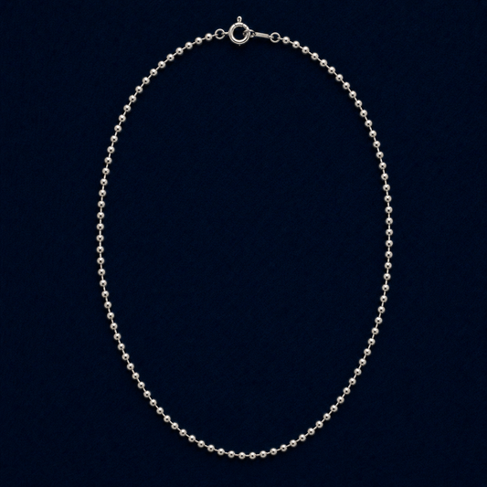 A full studio shot of the handcrafted Subtle Minimal Shine necklace in 925 sterling silver, featuring a delicate silver bead chain design on a dark navy background.