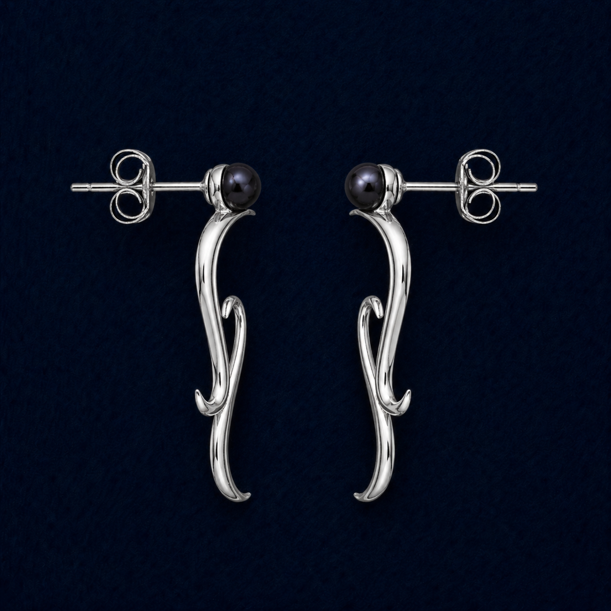 A technical studio shot of the Symphony earrings highlighting the wavy rhodium-plated drops, the integrated blue water pearl studs, and the secure pushback closure mechanism.