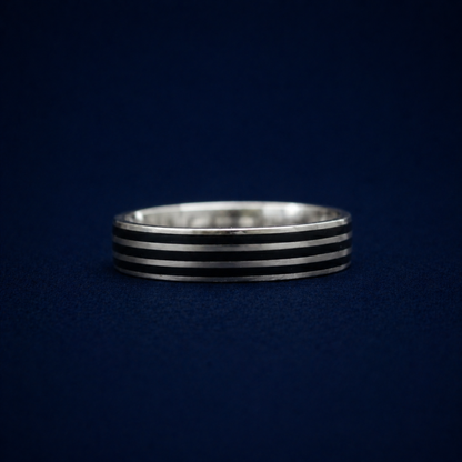 Frontal studio view of the Midnight Trio Ring, displaying the subtly bold triple black enamel line finish on a versatile, lightweight sterling silver band.