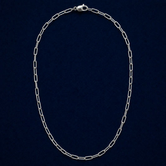 A full studio shot of the handcrafted Urban Paperclip Chain necklace in 925 sterling silver, featuring a sleek elongated link design on a dark navy background.