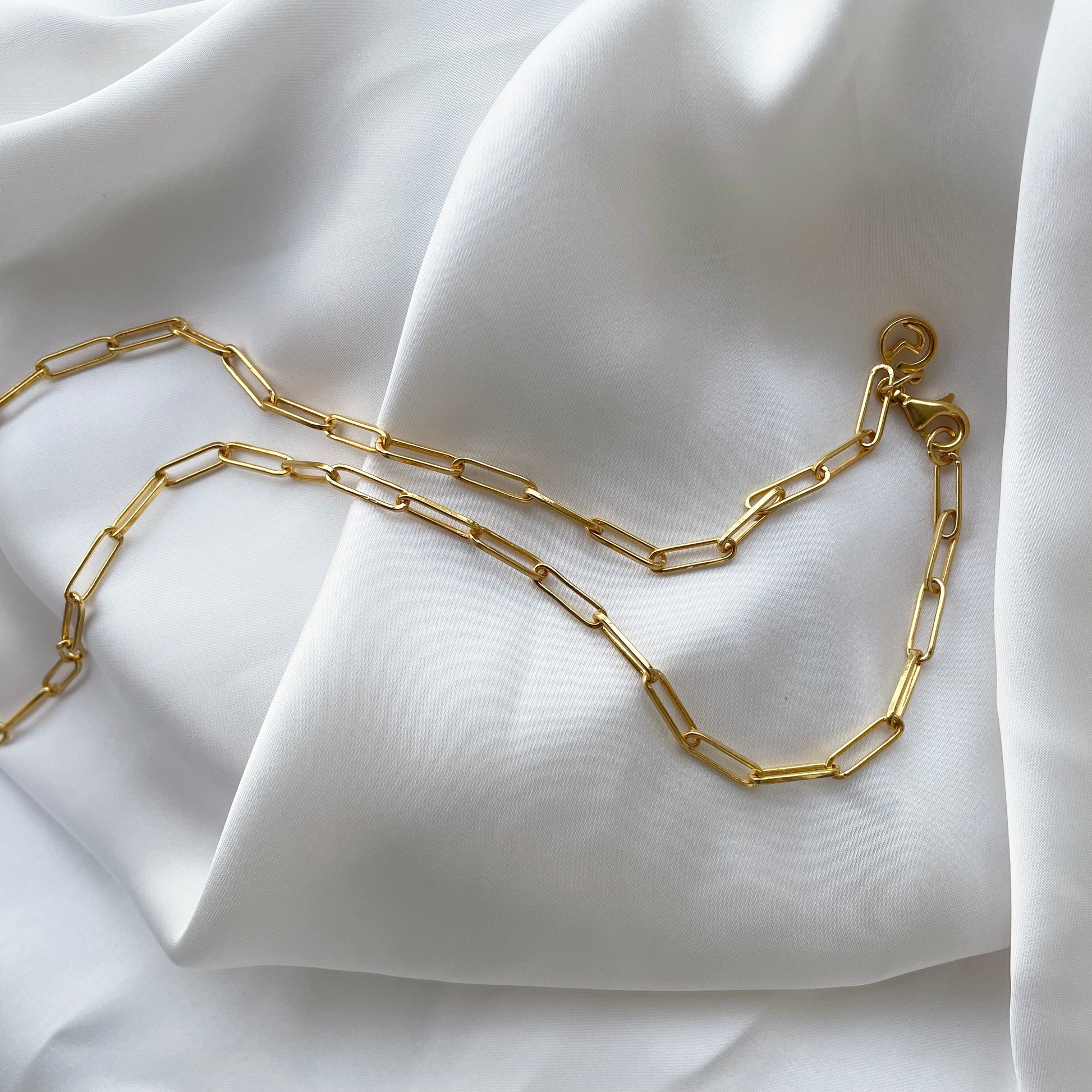 A beautiful studio layout of a minimalist silver link necklace, capturing its polished texture and elegant design for an everyday jewelry collection.