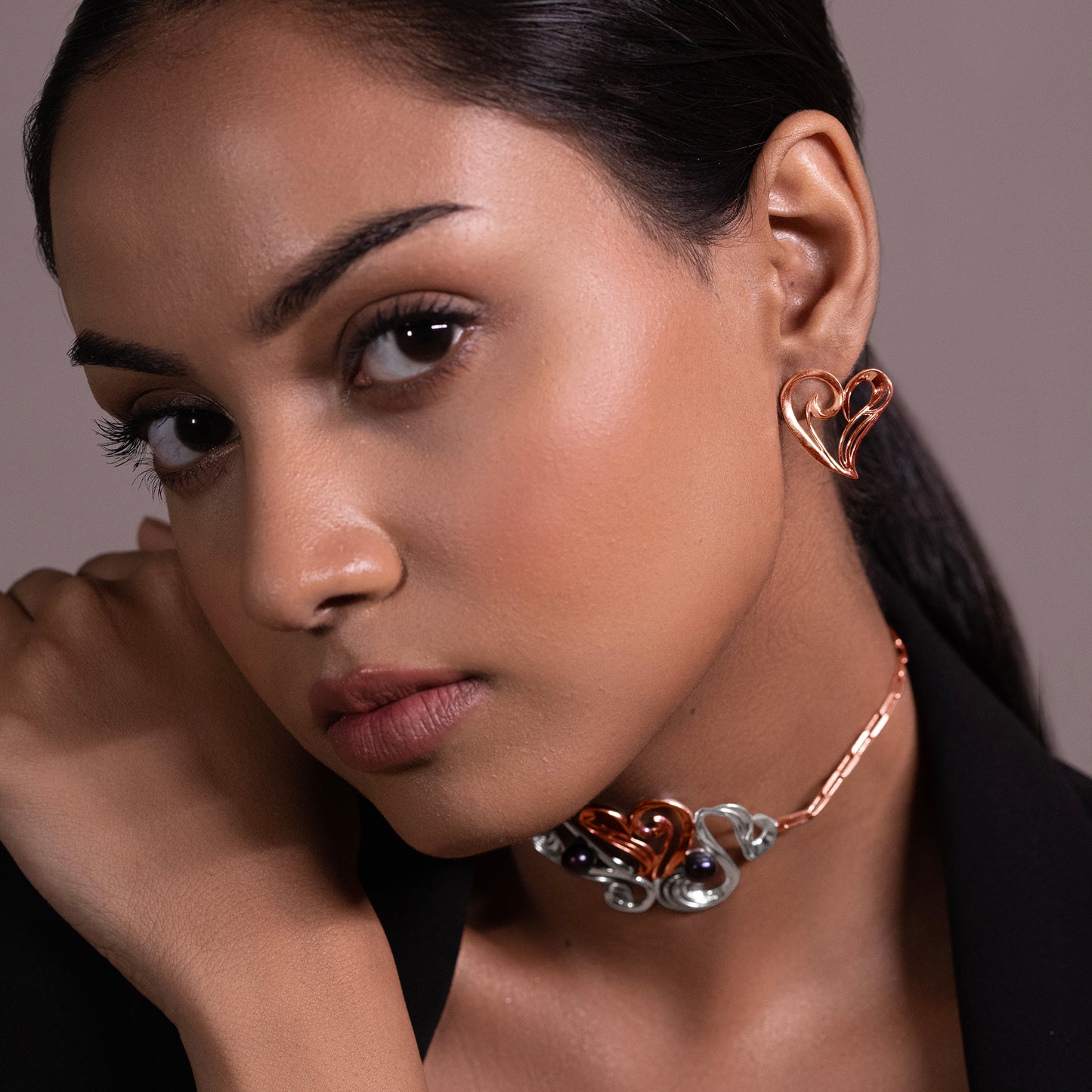 A model showcasing elegant rose gold heart studs handcrafted in 925 sterling silver, featuring a thick micron plating for long-lasting brilliance.