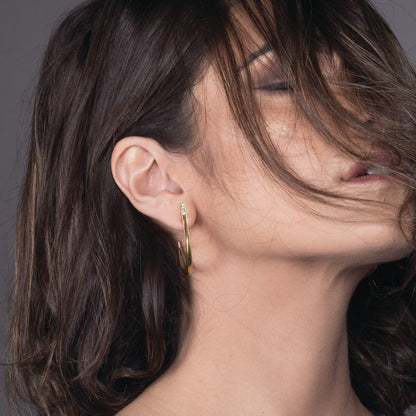 Close-up profile view of a model wearing the La Luna Earring in yellow gold, demonstrating how the celestial crescent moon jacket hugs the earlobe.