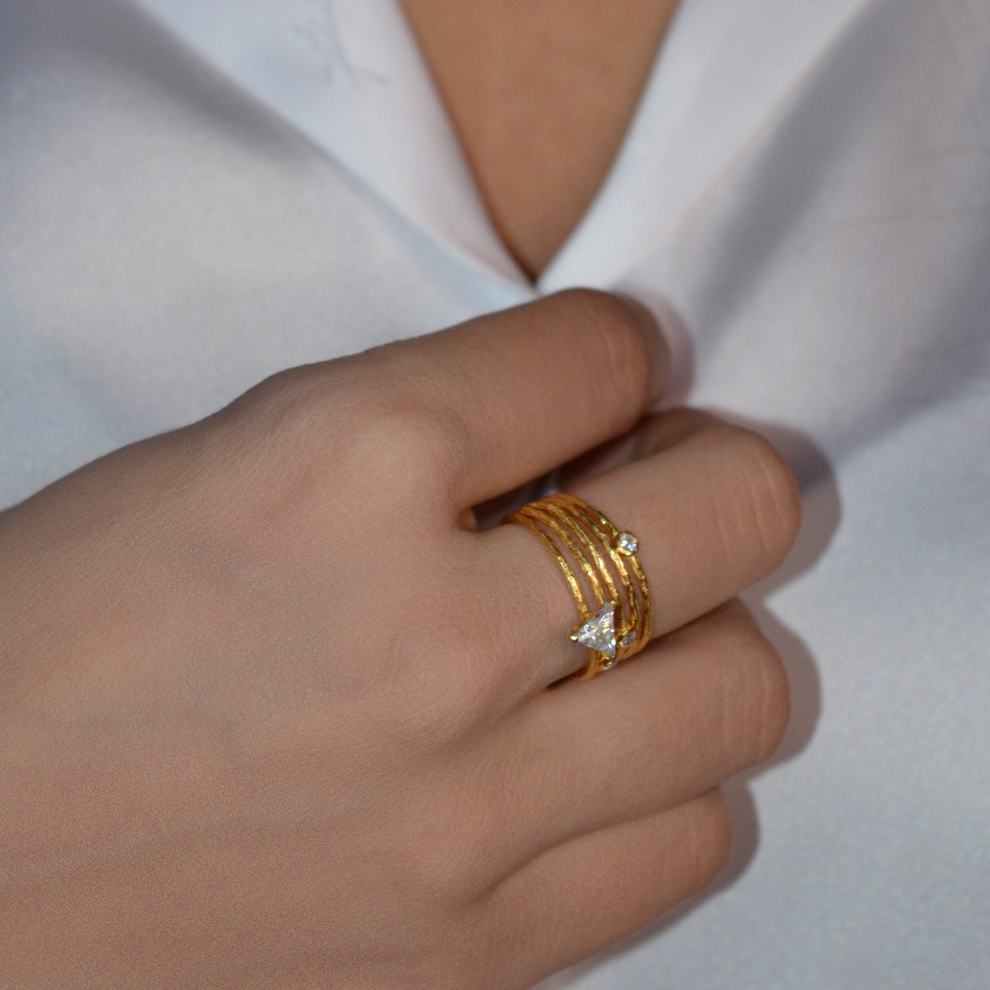 Model hand wearing a curated stack of delicate silver star rings, styled for sophisticated everyday wear.