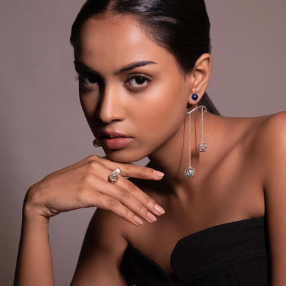 Side profile of a model featuring ornate silver-toned chandelier earrings with vibrant blue lapis inlays and delicate jali metalwork.