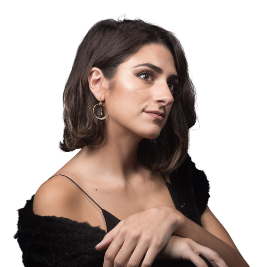 Lifestyle shot of a woman in a black faux fur wrap showcasing a gold-toned double hoop earring with a dangling star and crystal moon charm.