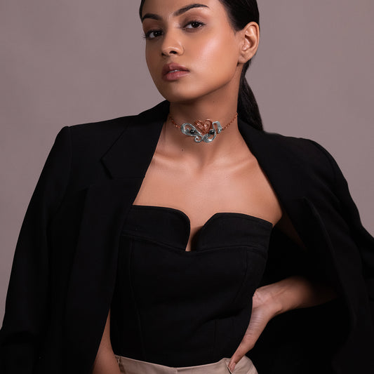 Side profile of a person wearing a bold, contemporary silver neckpiece that contours to the collarbone with a high-shine, liquid-like finish.