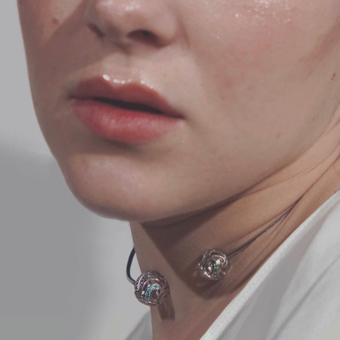 A model wearing a striking, wave-like brass choker that elegantly contours to the neck for a sophisticated, artistic look.