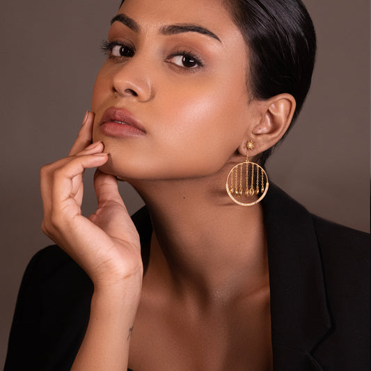 A person showcasing luxurious gold-toned tiered earrings with star-shaped accents and high-quality zirconia embellishments, highlighting a secure and comfortable fit.