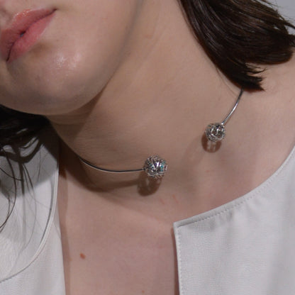 Portrait of a model wearing a modern, fluid-style brass collar, emphasizing its clean lines and versatility for formal or evening styling.