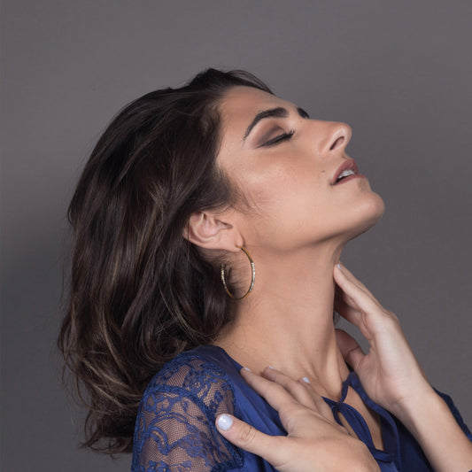 Pair of gold-toned huggie hoop earrings featuring a textured, molten-metal surface for a rustic, organic aesthetic.