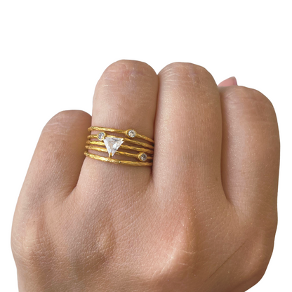 Close-up of a hand wearing a collection of dainty, star-studded stacking rings that create an elegant, shimmering celestial effect across the fingers.
