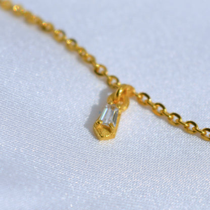 An elegant yellow gold chain necklace with petite, minimalist accents, designed for layering or sophisticated everyday wear, shown against a clean background.